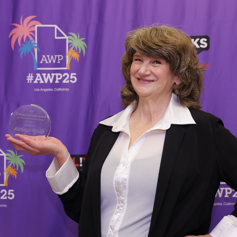Kathryn Kysar holding George Garrett Award and smiling in front of AWP25 backdrop