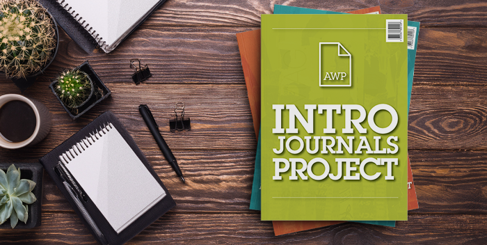 Bird's-eye view of a desk with stack of journals that say AWP Intro Journals Project