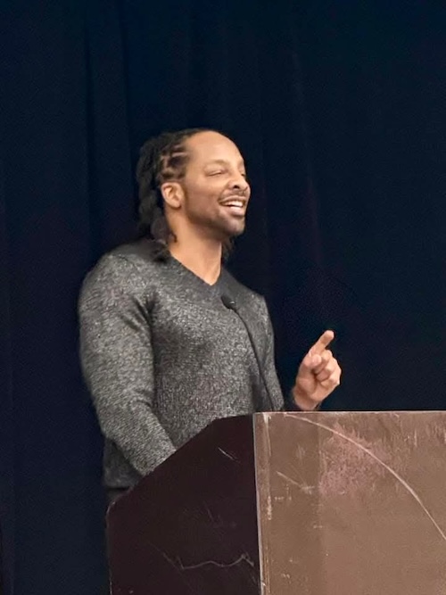 Jericho Brown smiling while speaking at a podium